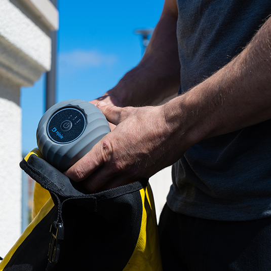 placing the vibrating peanut massage roller in a backpack