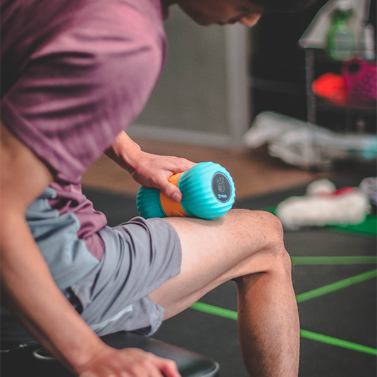 vibrating peanut massage roller on quad muscles